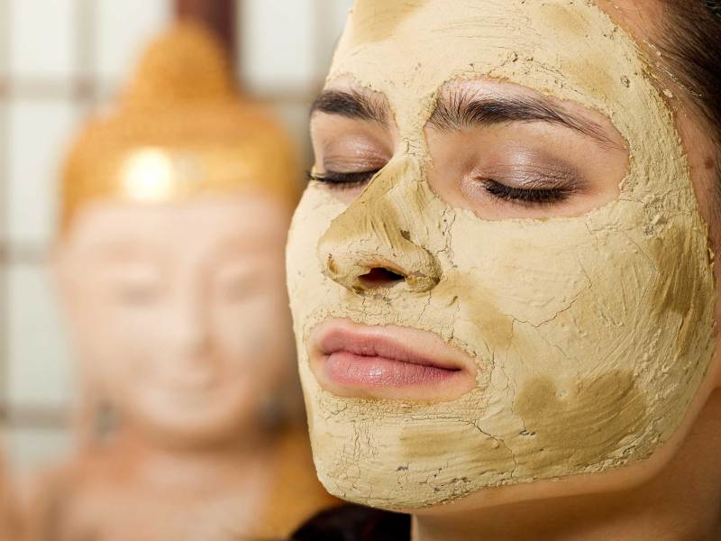 junge frau genie&szlig;t heilerde gesichtsmaske
