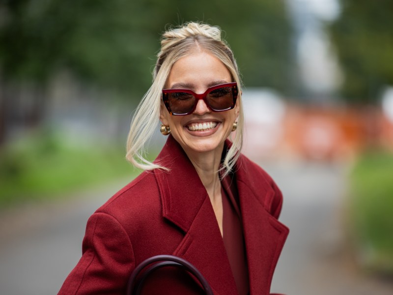Leonie Hanne mit hellblonden Haaren und einem burgunderroten Outfit.