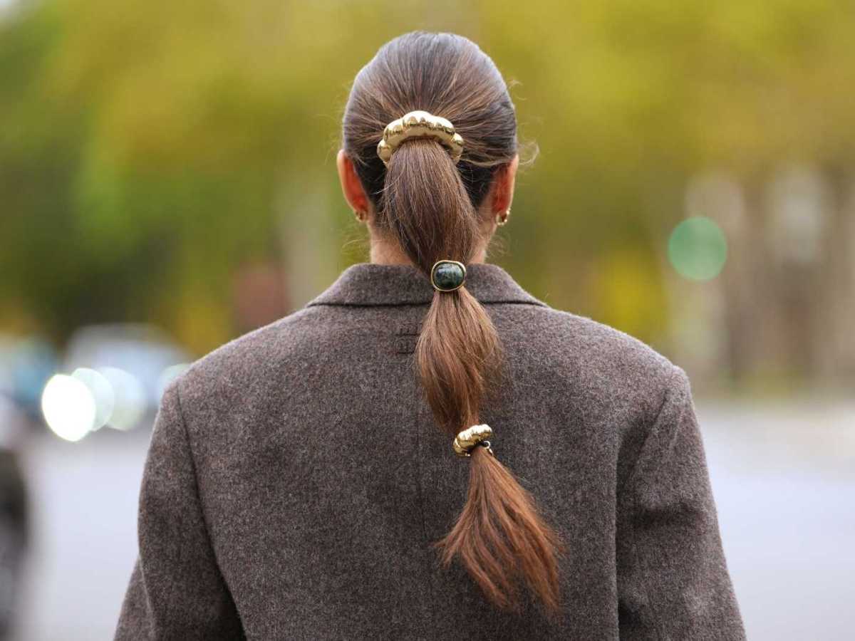 Lange braune Haare sind zu einem Zopf gebunden