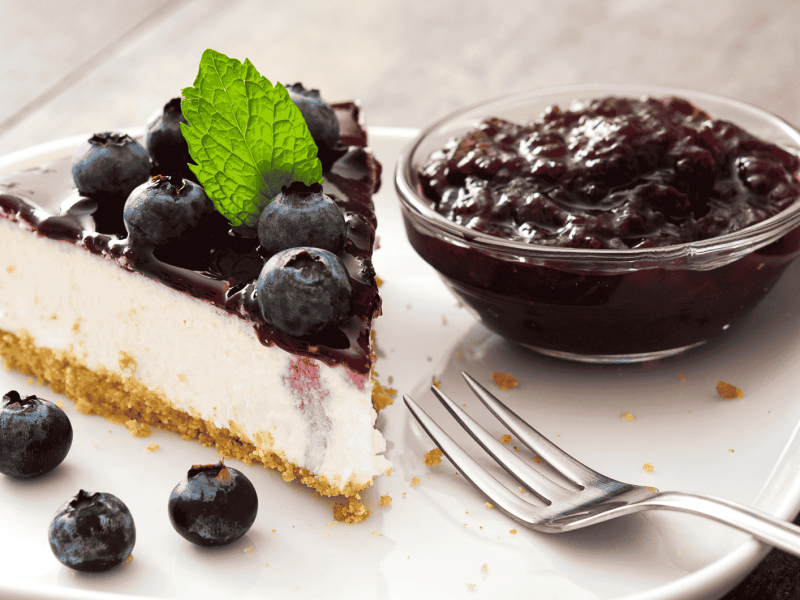 Blueberry Cheesecake auf einem wei&szlig;en Teller.