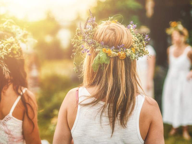 M&auml;dchen feiern Mittsommer und tragen Blumenkr&auml;nze.
