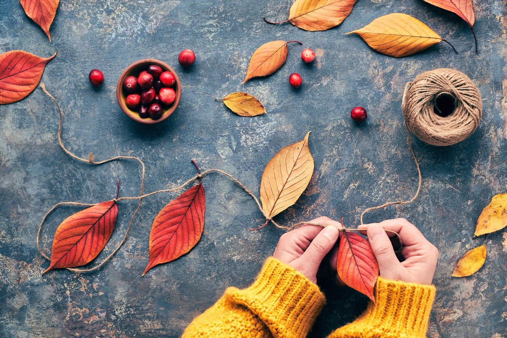 Person basteln eine Laubgirlande f&uuml;r den Herbst.