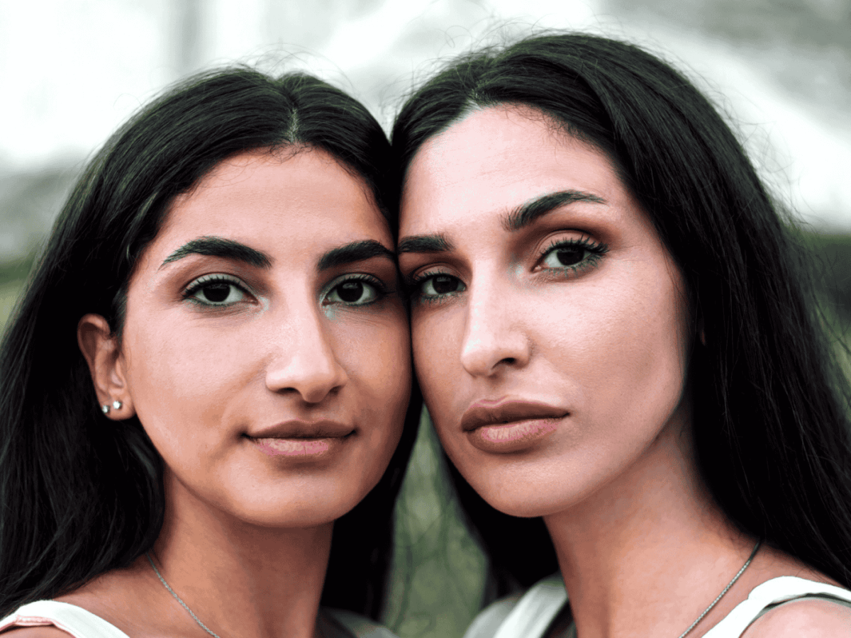Zwei Frauen stehen Wange an Wange nebeneinander