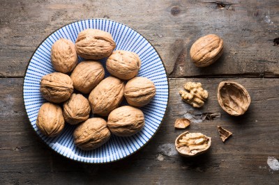 Waln&uuml;sse auf einem Teller als pflanzliche Quelle f&uuml;r Fols&auml;ure und wertvolle B-Vitamine in der Ern&auml;hrung.