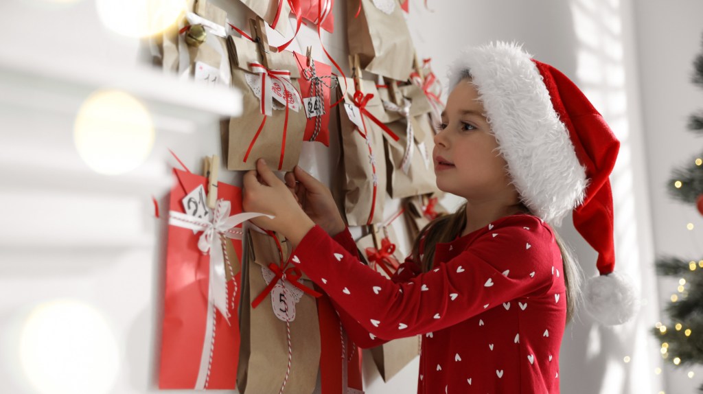 M&auml;dchen &ouml;ffnet Adventskalender.