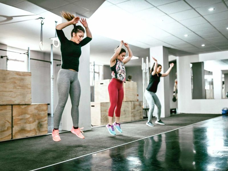 Sportliche Frauen trainieren gemeinsam in einem gro&szlig;en Sportraum