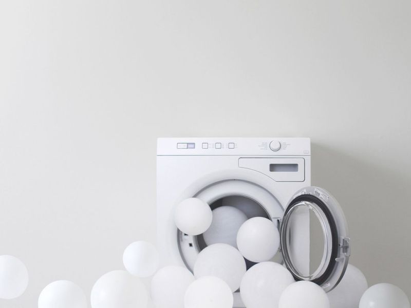 Waschmaschine mit wei&szlig;en Ballons.