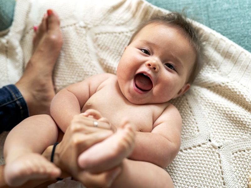 Baby liegt auf einem Handtuch und hat Spa&szlig;.