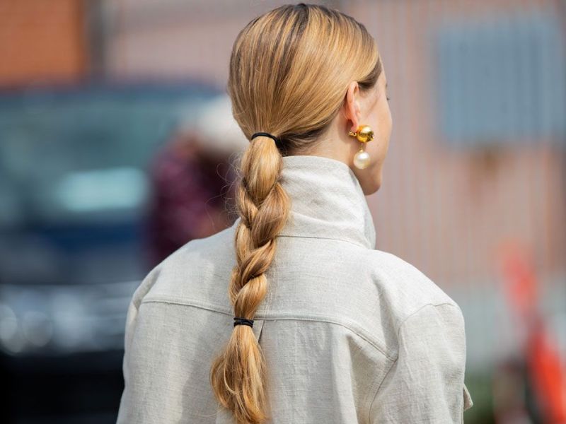 Frau mit dicken Haaren, die zu einem Pferdeschwanz gebunden sind.