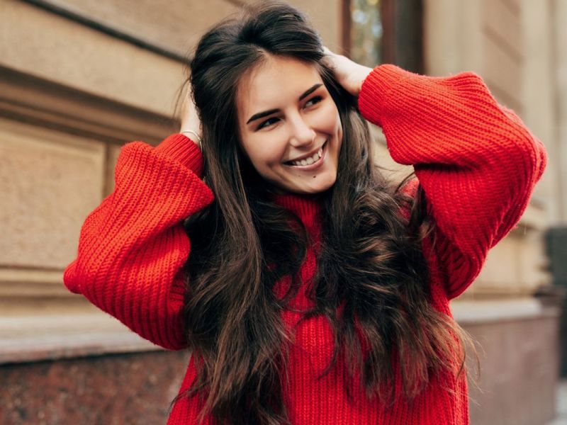 Frau mit schönen langen Haaren und rotem Pullover.