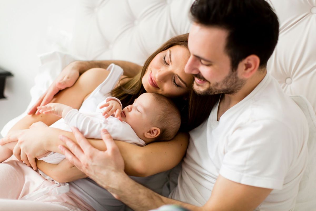 Mutter und Vater kuscheln mit ihrem Baby
