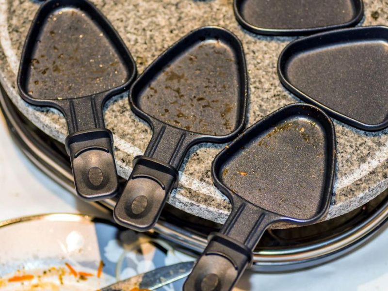 Schmutziges Raclette mit Pf&auml;nnchen, bereit zum Raclette reinigen