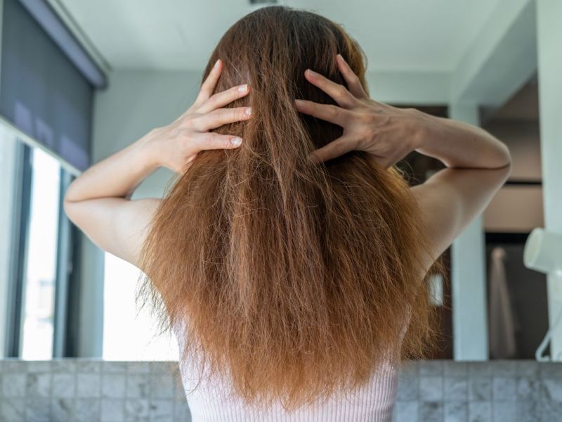 Frau mit strohigen Haaren in Hellbraun.