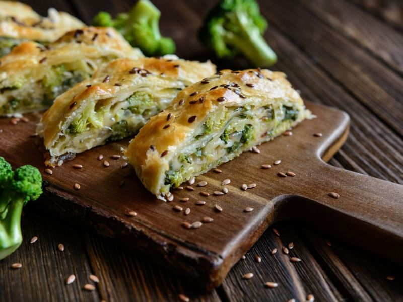 Brokkoli-Blätterteig-Strudel auf einem Holzbrett.