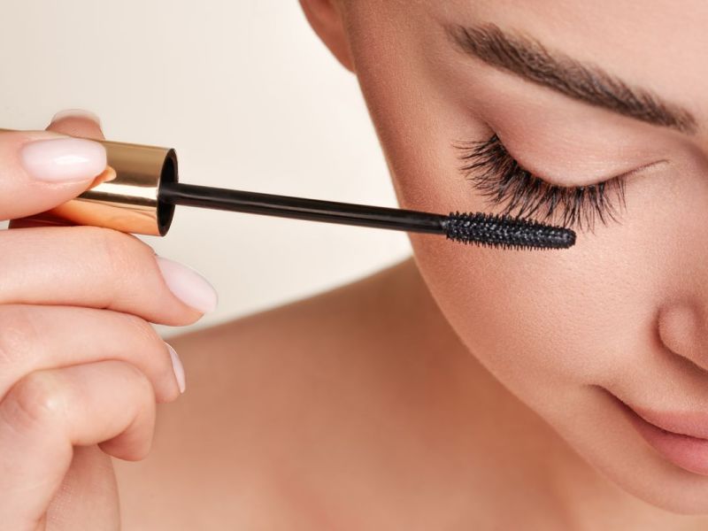Mascara Frau tuscht sich die Wimpern