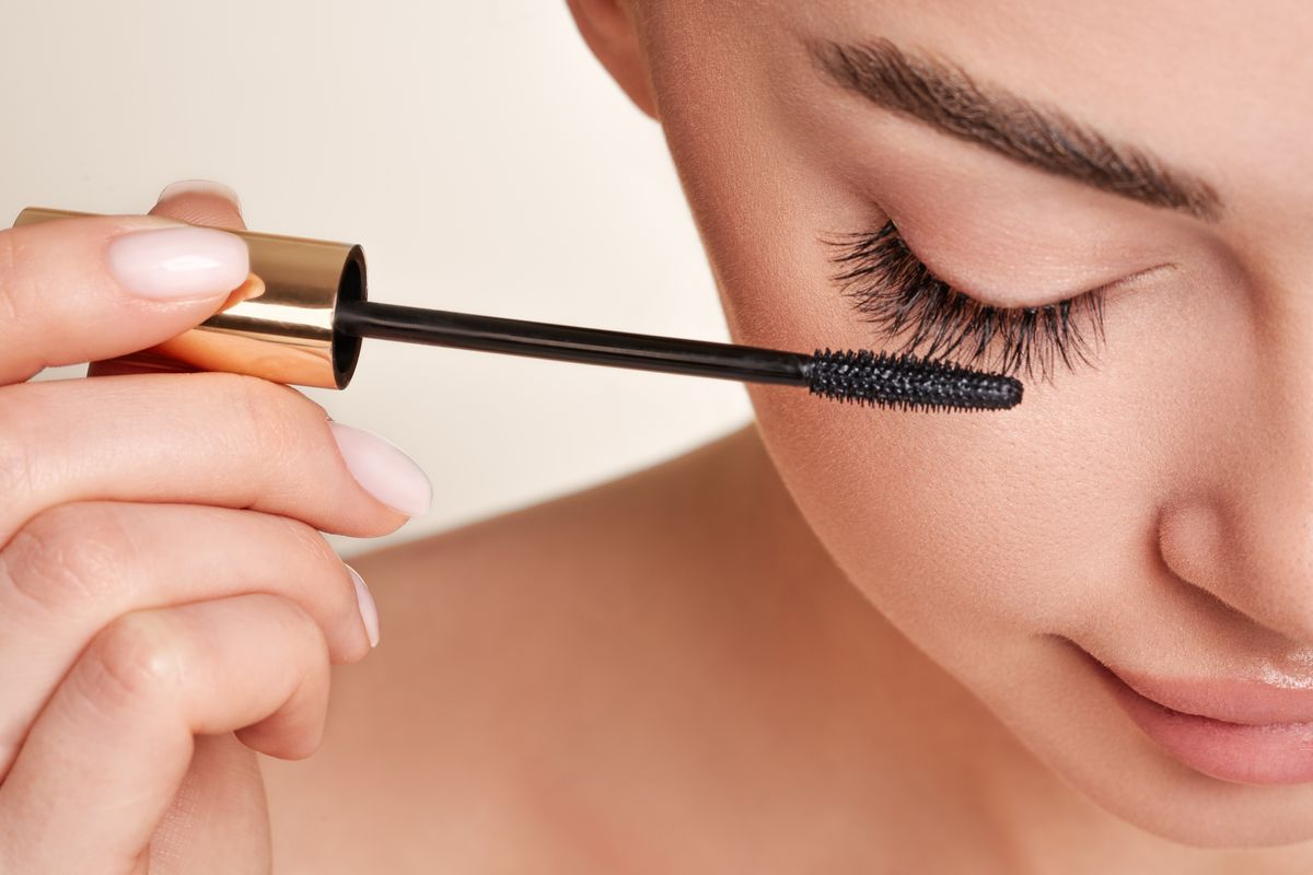 Mascara Frau tuscht sich die Wimpern