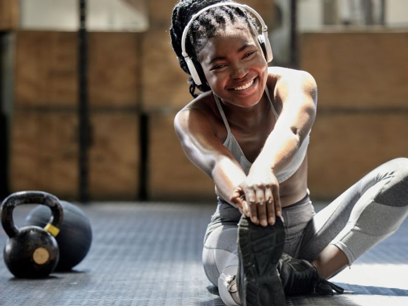 Frau dehnt sich im Fitnessstudio nach dem Sport.