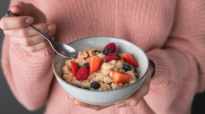 Schale mit frischem Haferbrei, N&uuml;ssen und Beeren als magnesiumreiches Getreidefr&uuml;hst&uuml;ck.