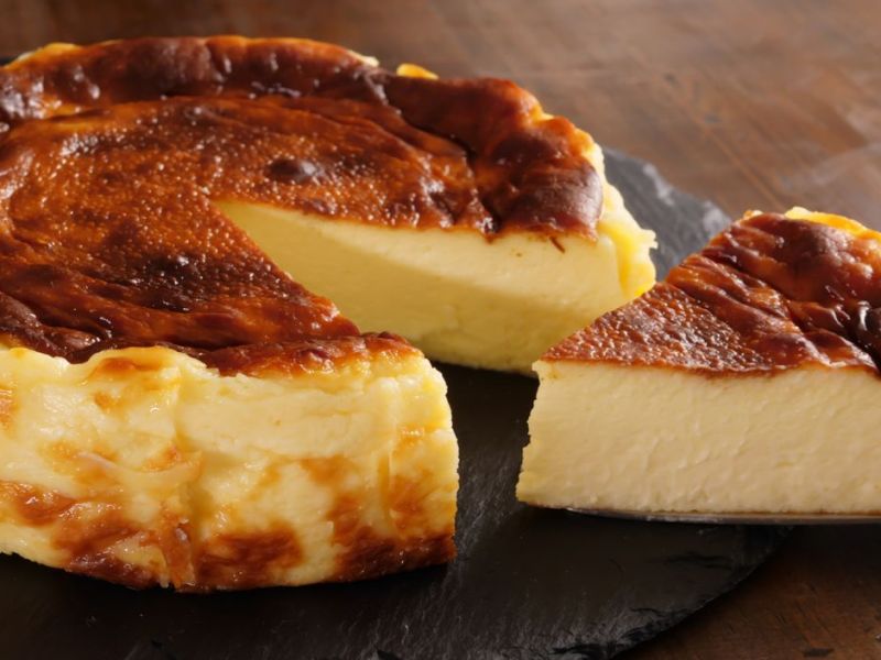 Joghurt-Kuchen auf dunkler Schieferplatte.