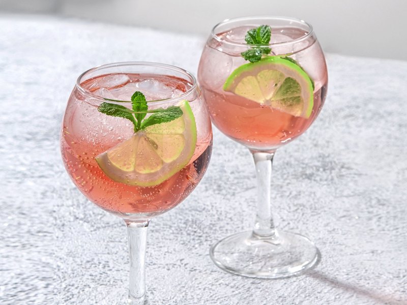 Sarti Spritz: Hellrosa Getr&auml;nk in Weingl&auml;sern mit Limettenscheiben