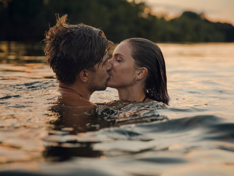 Paar k&uuml;sst sich im Wasser schwimmend