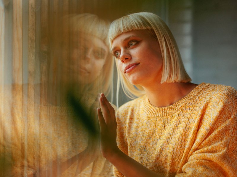 Junge Frau schaut aus dem Fenster
