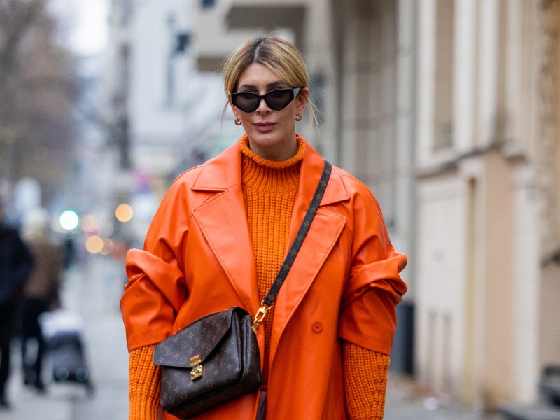 Street Style mit orangefarbenem Pullover und Mantel im Herbst.