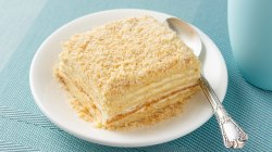 Kuchen mit vielen Cremeschichten auf einem wei&szlig;en Teller.