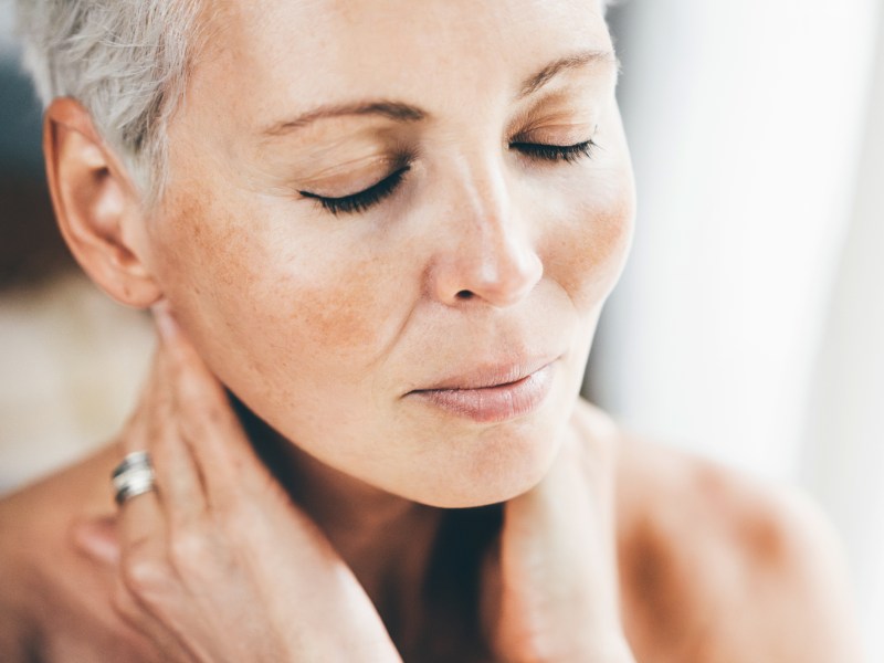 Frau tr&auml;gt Anti Aging Creme auf