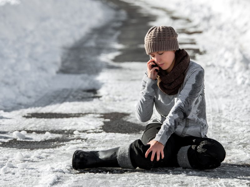 Frau, die bei Schnee und Glätte ausgerutscht ist