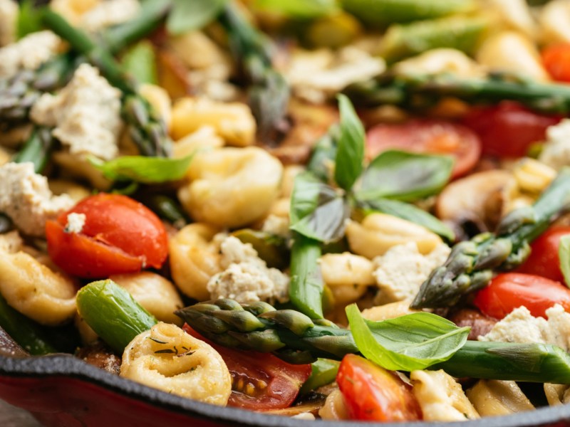 Nudelsalat mit Tortellini, gr&uuml;nem Spargel, Tomaten und Basilikum.