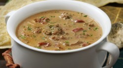 Suppe mit Tomaten, Hackfleisch und Paprika in wei&szlig;er Sch&uuml;ssel.