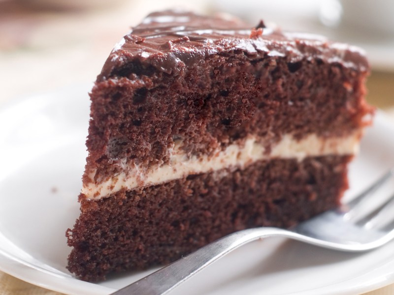 Schokotorte mit Sahne in der Mitte auf einem wei&szlig;en Teller.