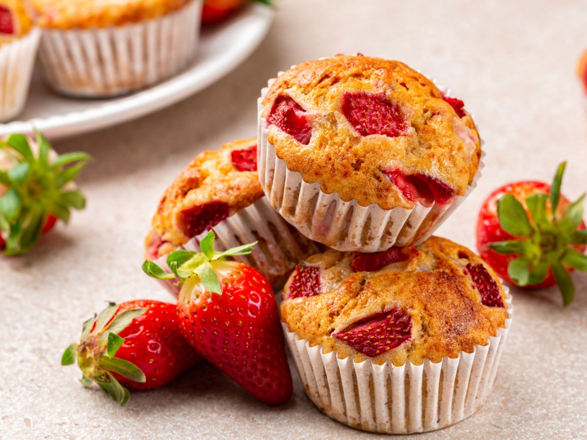 Mehrere Erdbeer-Muffins auf einem wei&szlig;en Tisch.