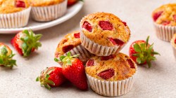 Mehrere Erdbeer-Muffins auf einem wei&szlig;en Tisch.