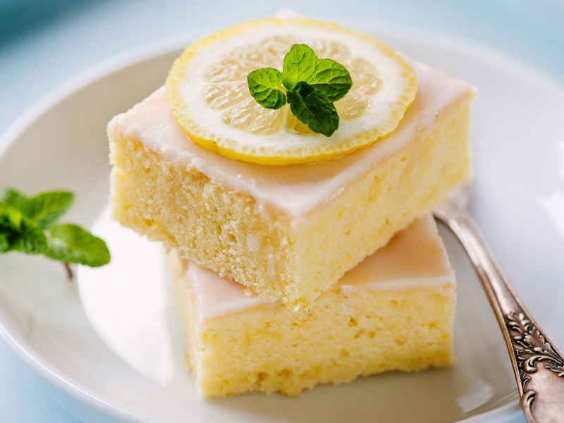 Zwei St&uuml;ck Zitronenkuchen auf einem wei&szlig;en Teller.