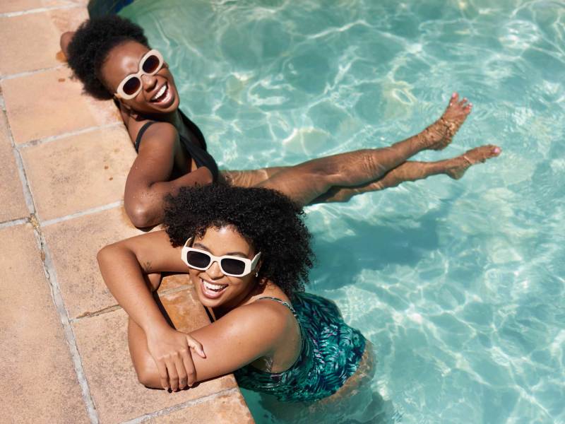 Zwei sch&ouml;ne Frauen k&uuml;hlen sich im Schwimmbad ab, Hitzewelle im Sommer