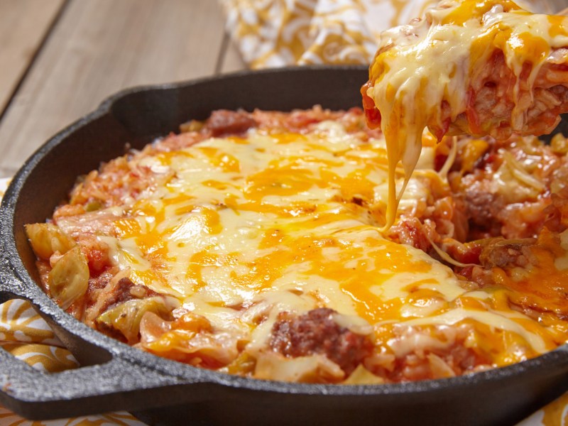 Überbackener Reis mit Hackfleisch und Käse in einer Gusseisenpfanne.