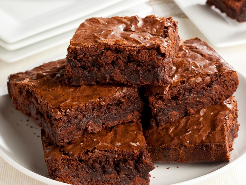 Mehrere Brownies aufeinander gestapelt auf einem wei&szlig;en Teller.