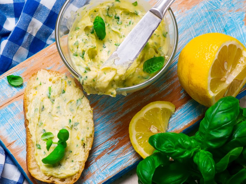 Kr&auml;uterbutter mit Zitrone und Basilikum in einer Glassch&uuml;ssel.