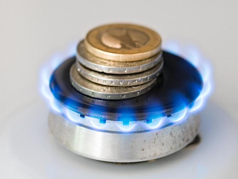 Geldm&uuml;nzen liegen auf einer Gasflamme.