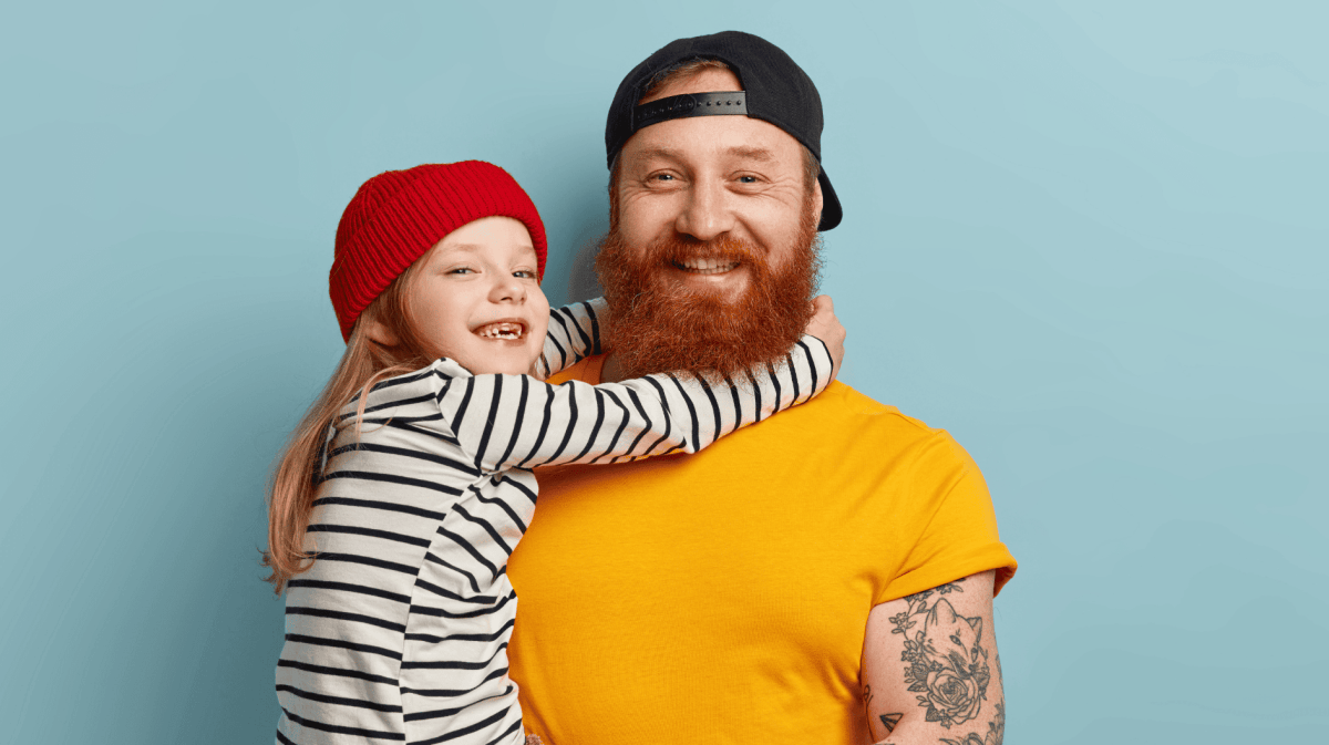 Vater hält kleines Mädchen auf dem Arm, das lacht