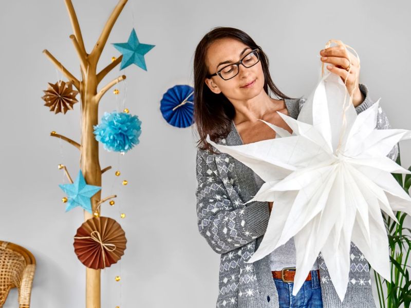 Eine Frau h&auml;lt einen selbstgebastelten Weihnachtsstern in der Hand