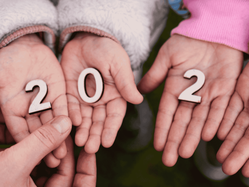 Kleine Holzzahlen 2026 liegen in kleinen Kinderhänden