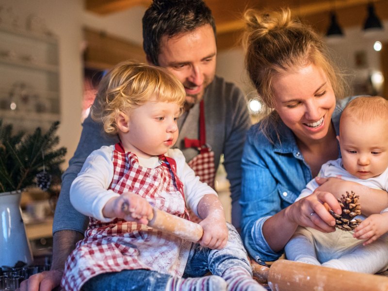 Junge Familie backt in der Weihnachtszeit Pl&auml;tzchen zu Hause.