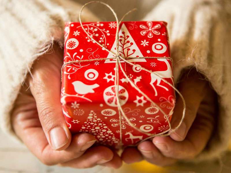 Frau h&auml;lt ein kleines rotes Wichtelgeschenk.