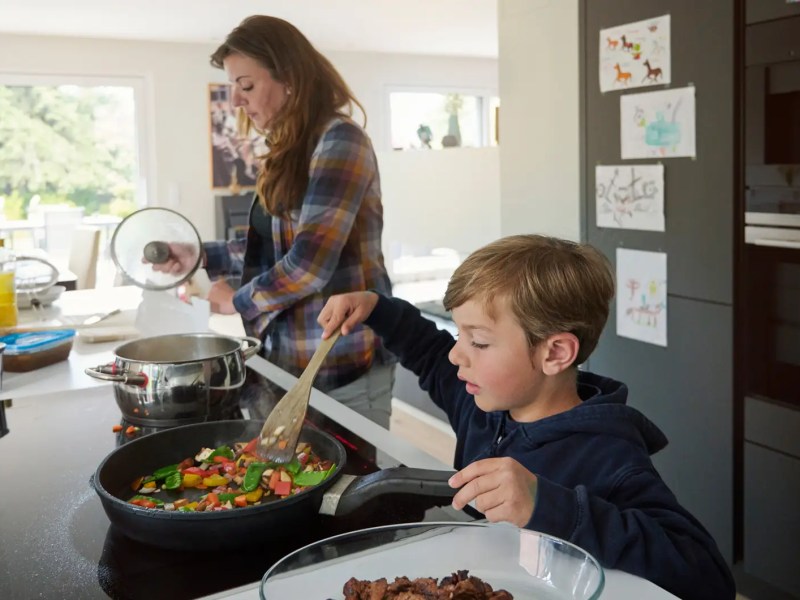 Mutter und Sohn kochen gemeinsam in der K&uuml;che.