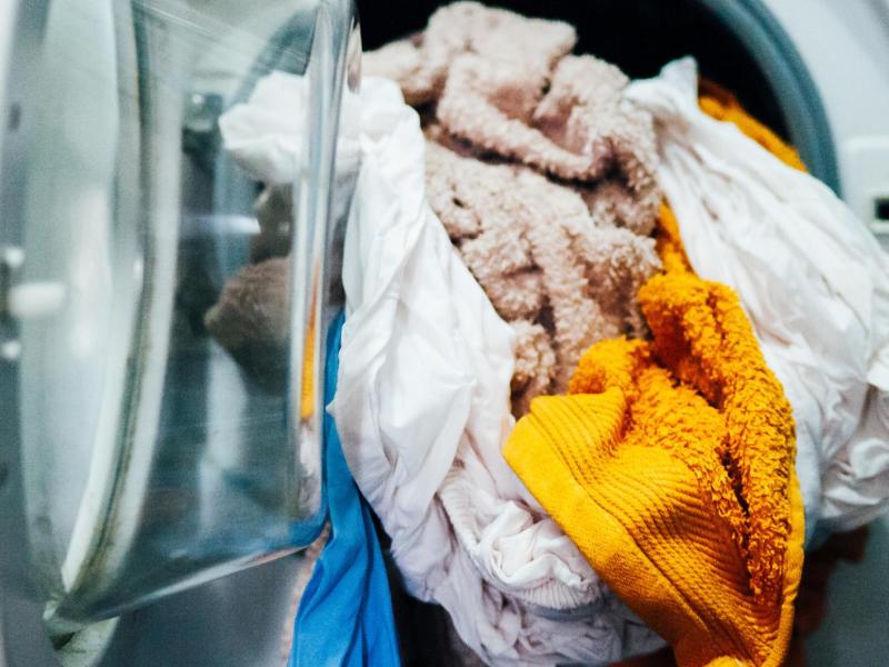 Handt&uuml;cher mit verschiedenen Farben sind nass in der Waschmaschine.