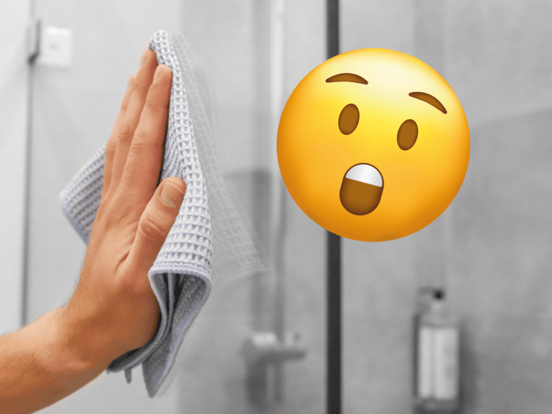 Eine Person putzt eine gl&auml;nzende Dusche mit einem Lappen