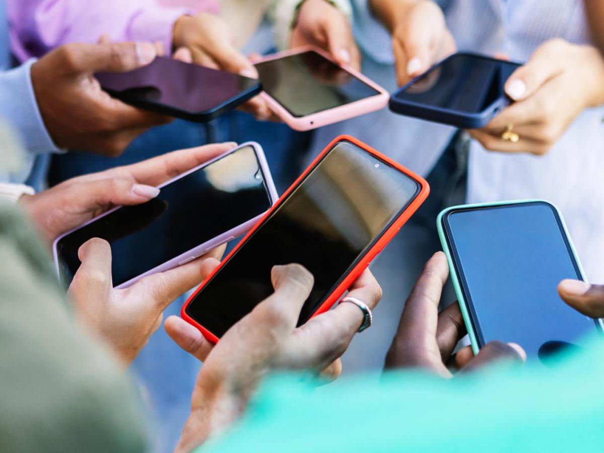 Mehrere Personen mit vielen verschiedenen Smartphones.